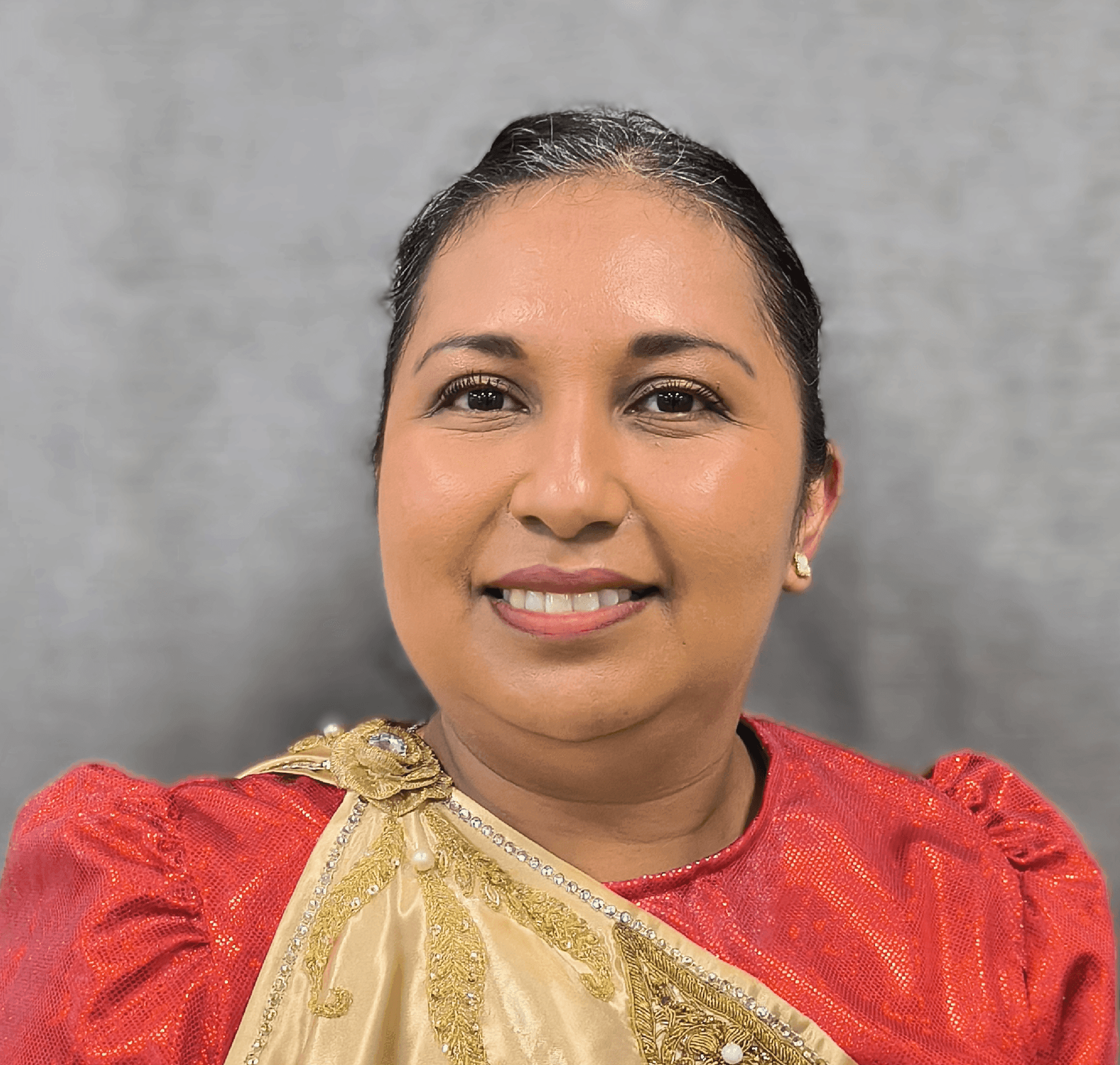 Smiling person wearing a red and gold traditional outfit against a gray background.
